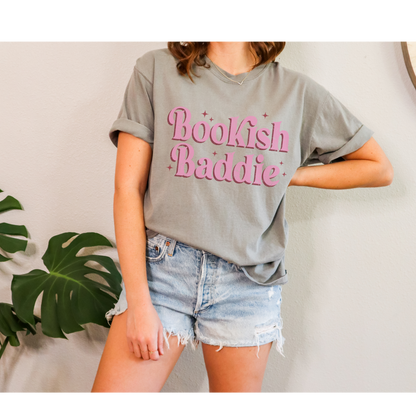 Elevate your bookish style with our "Bookish Baddie" Graphic Tee. This eye-catching piece combines a pop of pink with an empowering message, creating a fun and uniquely fashionable look that's perfect for all the confident book lovers out there.