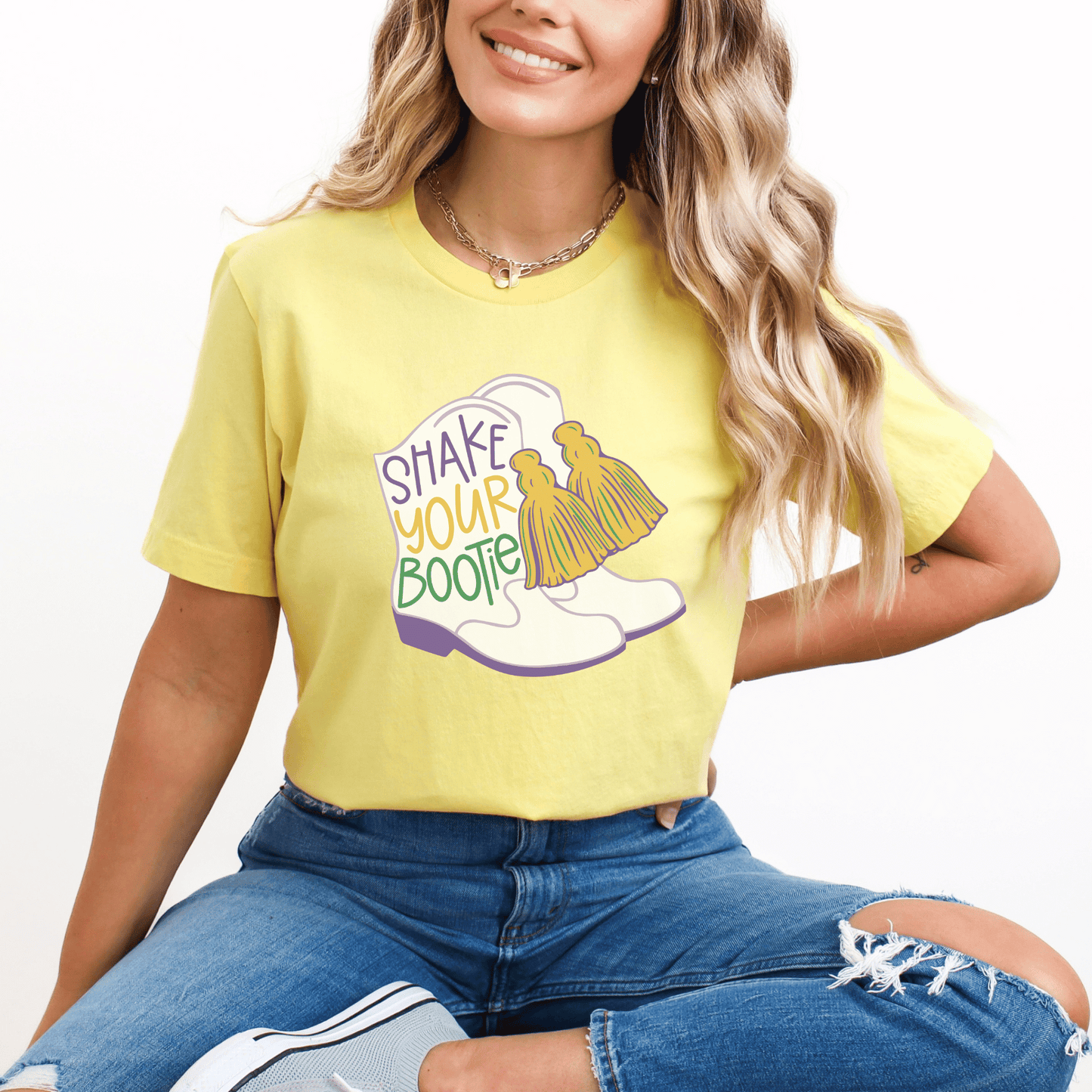 Womens funny yellow mardi gras shirt saying shake your bootie with an image of majorette boots